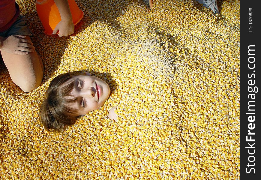 Little girl covered in corn with other children. Little girl covered in corn with other children.