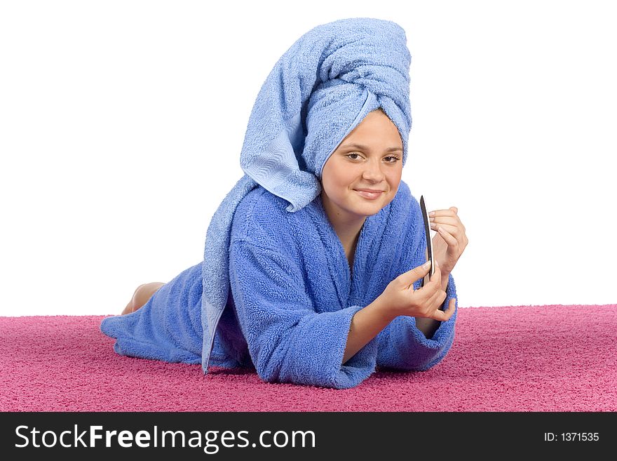 Young woman dressed blue bathrobe and towel filing nails