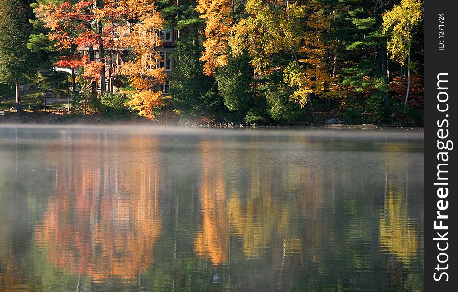 Autumn lake reflection in the Muskoka region of Canada with brilliant colors