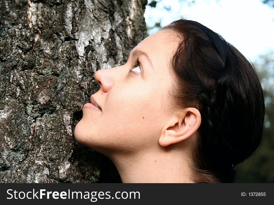 Portrait of a young woman leans on a tree. Portrait of a young woman leans on a tree
