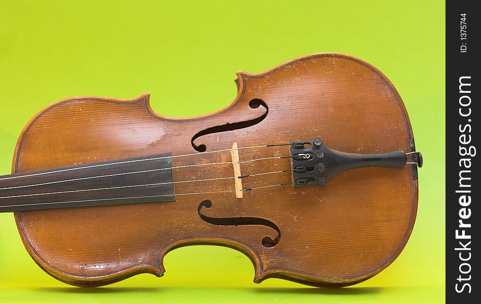 Old violin with shadows (not isolation) on a green background