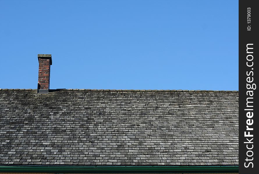 Shingled roof against blue sky, suitable for backgrounds or industry illustration