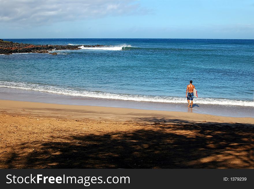 A surfer heading out on the island of Molokai Hawaii. A surfer heading out on the island of Molokai Hawaii