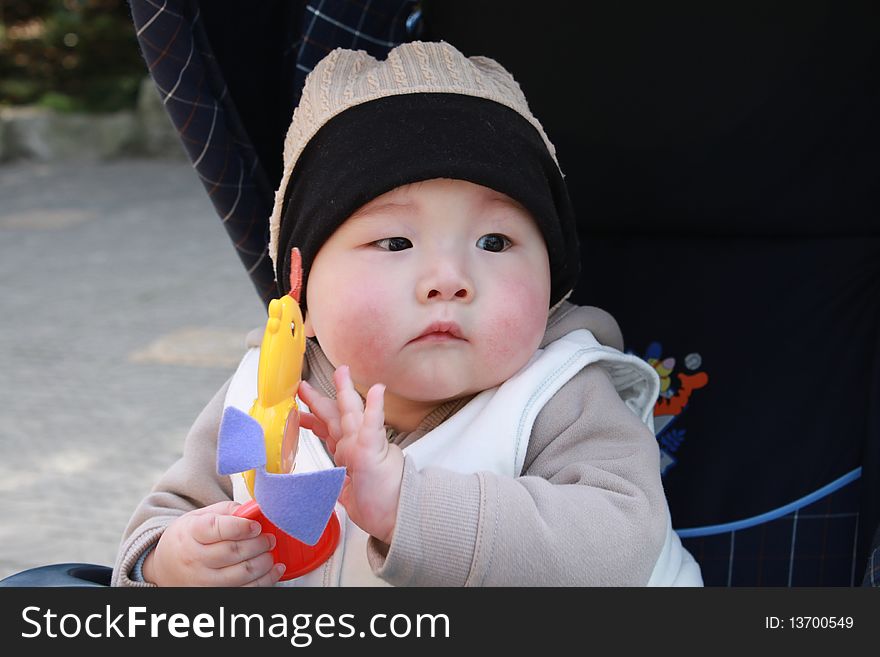 Lovely Chinese baby playing toy in the park. Lovely Chinese baby playing toy in the park