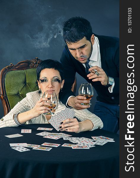 There is cool couple. He smokes cigar and hold glass with cognac. There is cool couple. He smokes cigar and hold glass with cognac.