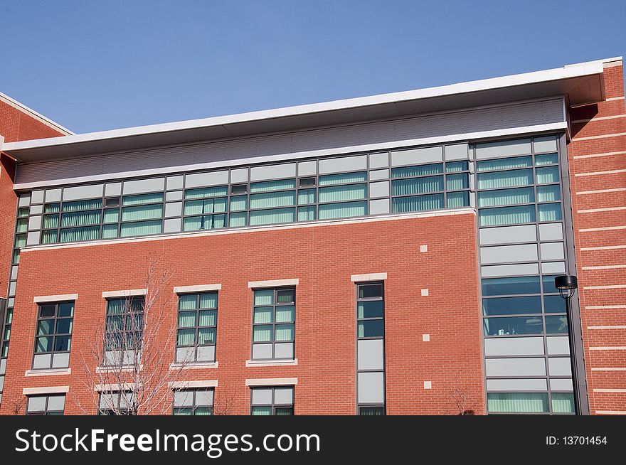 Modern brick and glass building in spring with blue skies. Modern brick and glass building in spring with blue skies