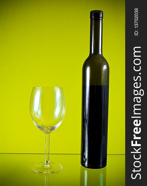 Glass, wine bottle on yellow background