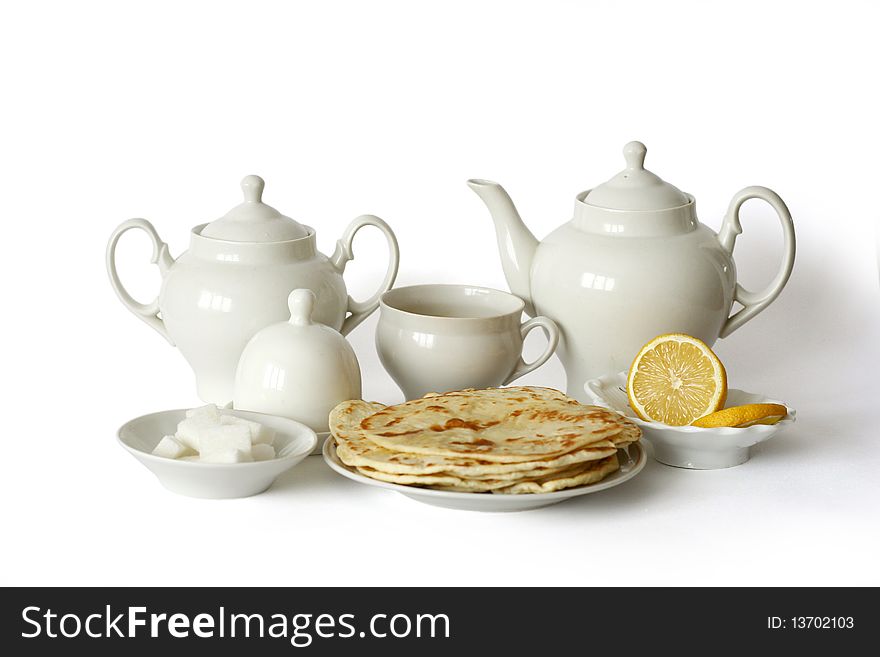 Tea set with flat cakes on white background