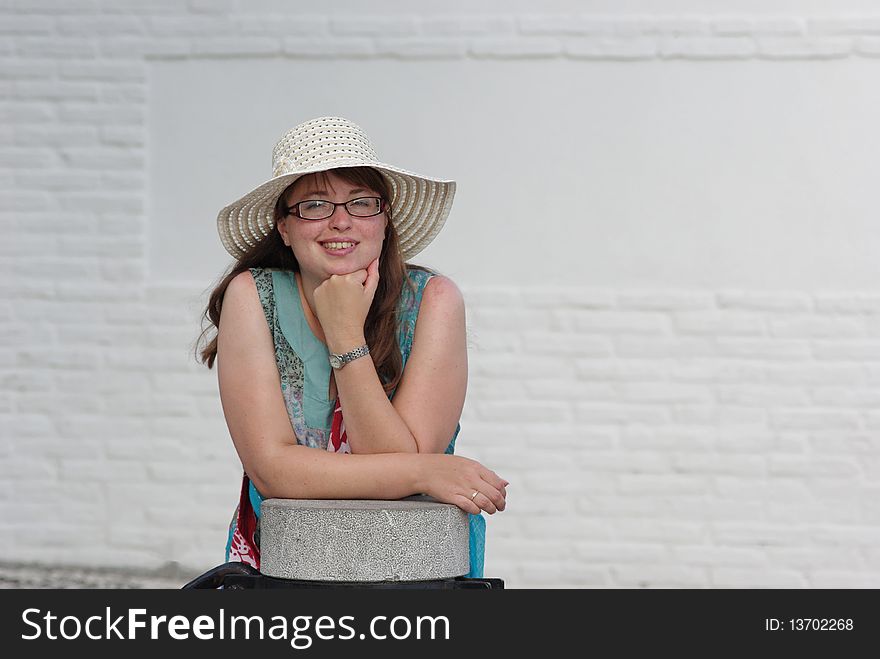 Portrait of a happy young woman wearing a hat against a white wall. Granada in Spain Excellent Copy Space. Portrait of a happy young woman wearing a hat against a white wall. Granada in Spain Excellent Copy Space