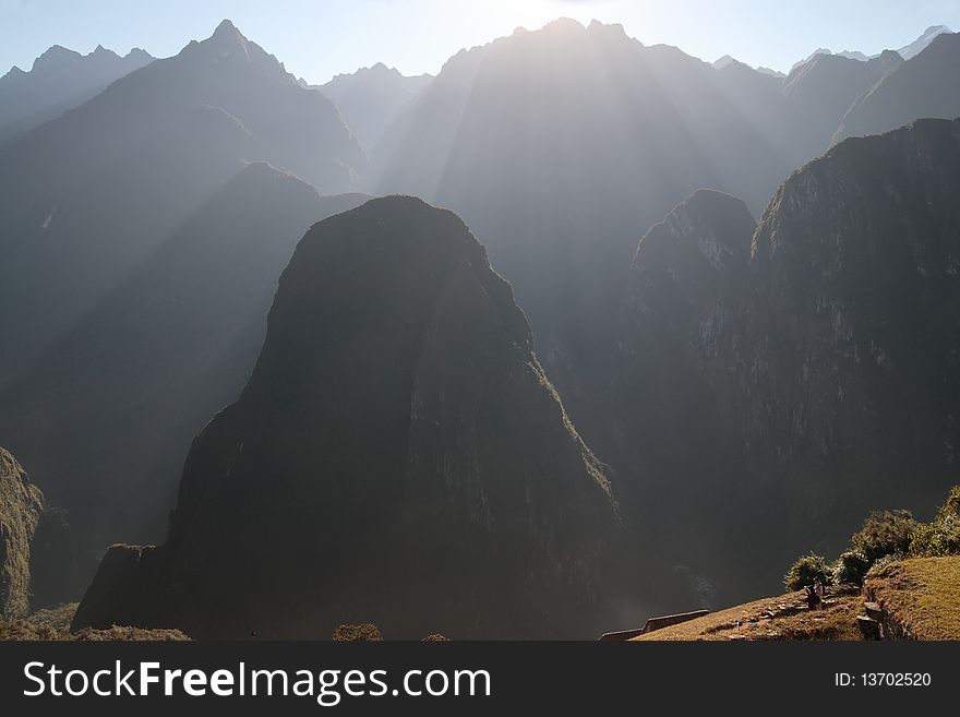 Shafts of sunlight over hills near Machu Picchu ruins