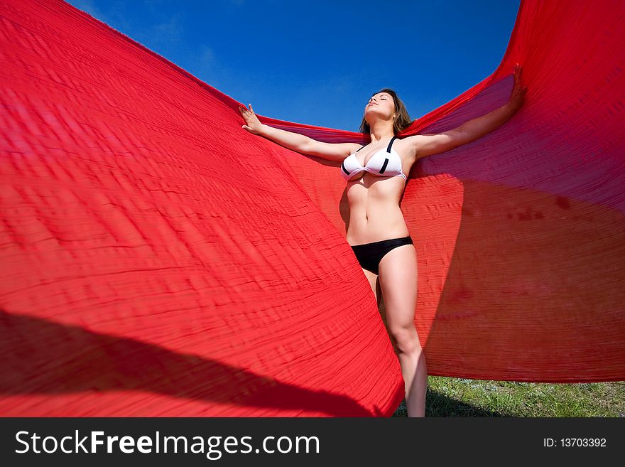 Young beautiful woman standing with red material. Young beautiful woman standing with red material