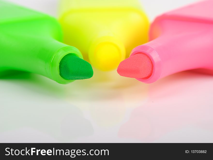 Some multi-coloured markers lie nearby on white background