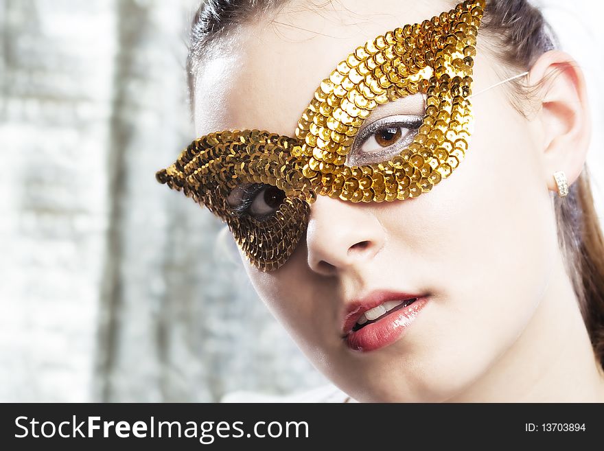 Young Woman Wearing Golden Mask