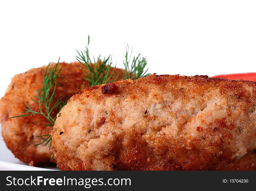 Ready cutlets are laid out on a white plate with a fennel branch.