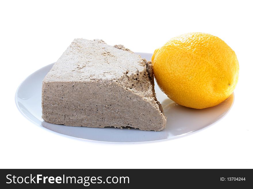 Halvah with a lemon on a plate, a background - white. Halvah with a lemon on a plate, a background - white.