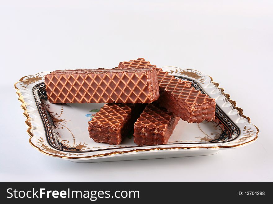 Wafers in chocolate glaze on a ceramic plate.