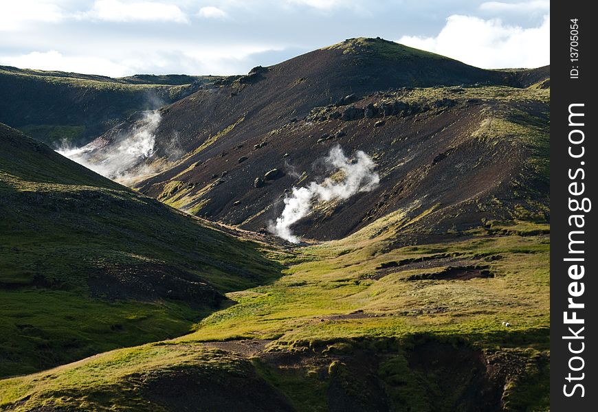 Steaming River, Black Lava Mountains And Sheep In