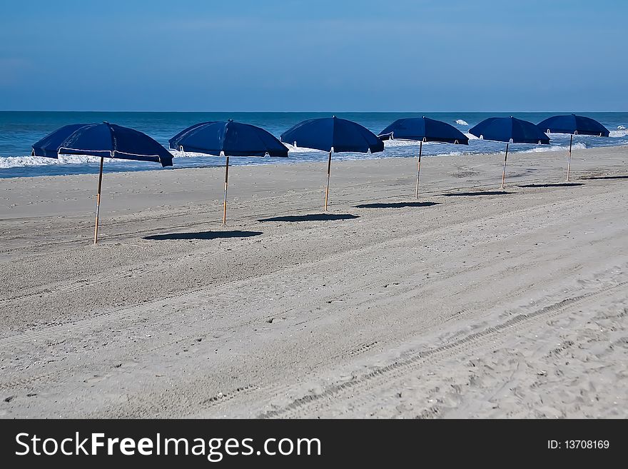 6 beach umbrellas,blue sky,calm. 6 beach umbrellas,blue sky,calm