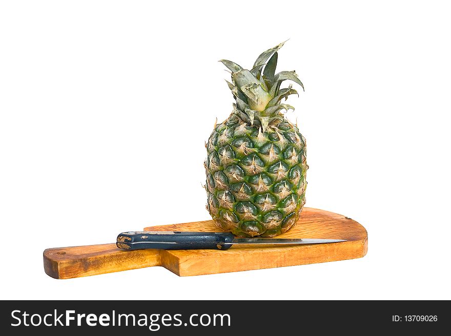 Pineapple, cutting board and knife, isolated on a white background.