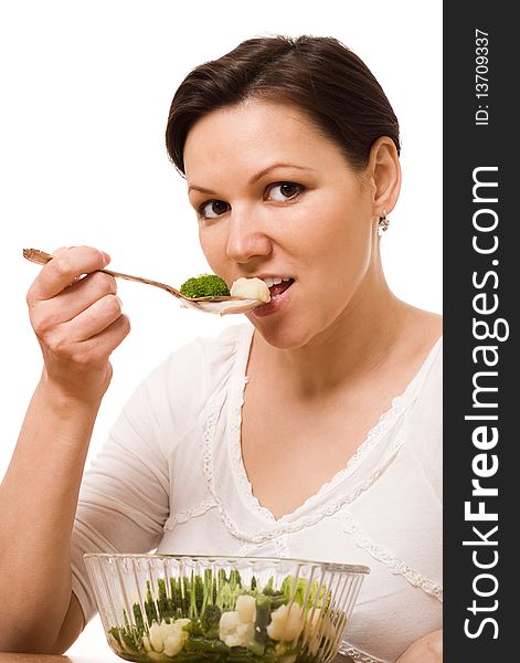 Beautiful pregnant woman eats vegetables on white