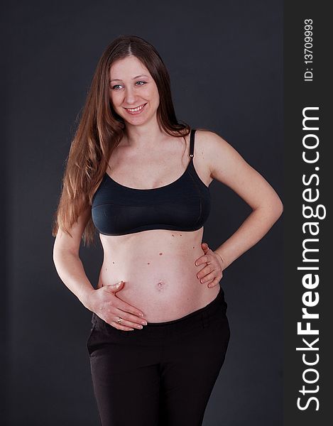 Nine month pregnant beautiful woman holding her belly to getting touch her unborn baby. Nine month pregnant beautiful woman holding her belly to getting touch her unborn baby.