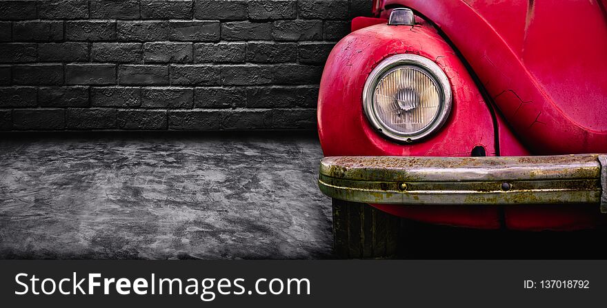 Front view of detail headlight old red car in dark garage background