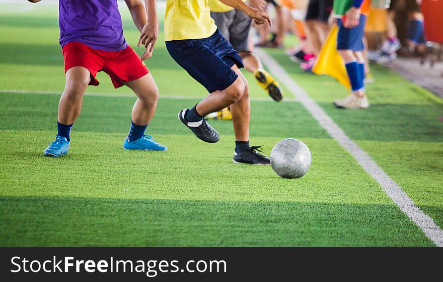 Soccer players run to trap and control the ball for shoot to goal with cheerleader team background. Soccer players fighting each other by kicking the ball