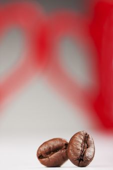 Two Coffee Beans Against Red Cups Royalty Free Stock Images Two Coffee Beans Against Red Cups Royalty Free Stock Images