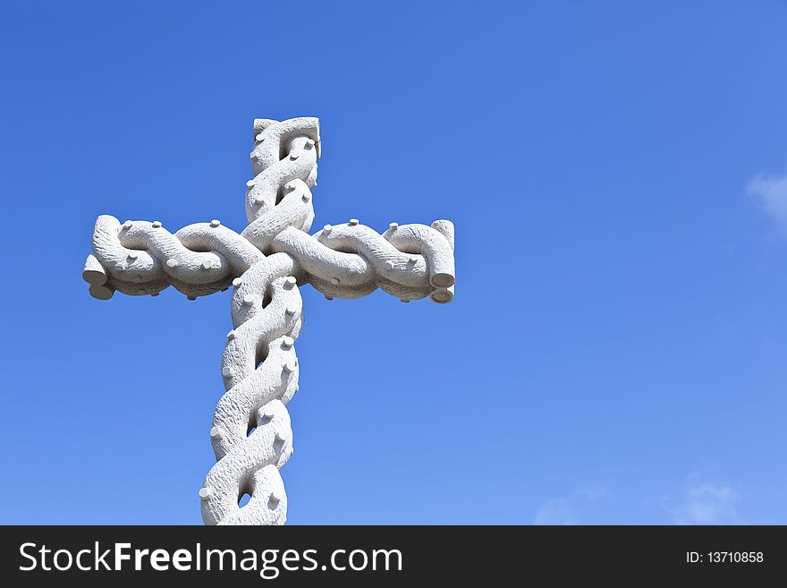 Stone cross with interlaced design over blue sky. Stone cross with interlaced design over blue sky