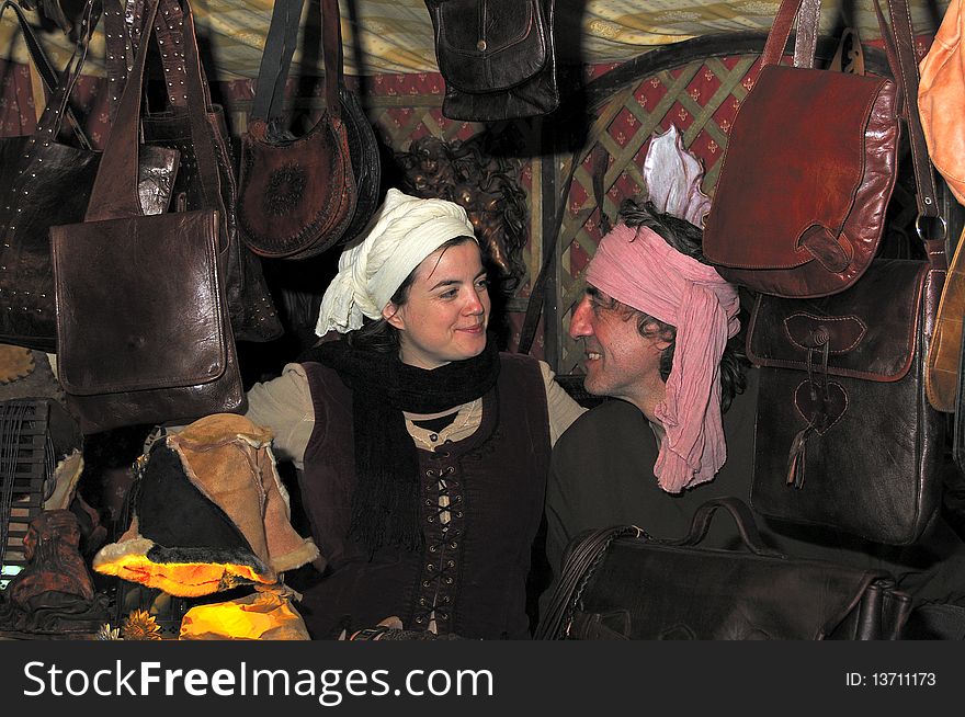 A man and woman smiling, faceing one another, surrounded by hand made leather bags. A man and woman smiling, faceing one another, surrounded by hand made leather bags.
