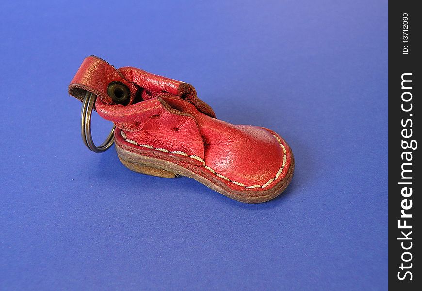 Red leather shoe for keeping key isolated on blue. Red leather shoe for keeping key isolated on blue