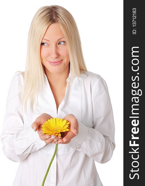 Young smiling blonde in a white shirt plays with a yellow flower in the hands