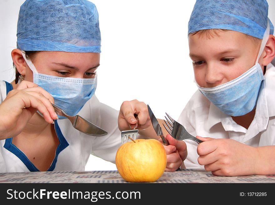 Two teens operating on a apple. Two teens operating on a apple