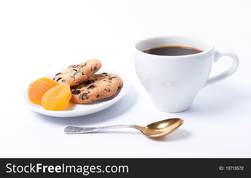 A cup of coffee with dried apricots and chocolate cookies. A cup of coffee with dried apricots and chocolate cookies