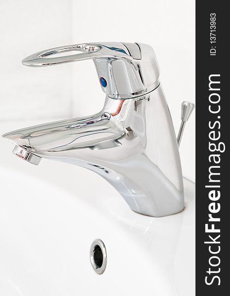 One chrome faucet in washbowl in bath room o white pile