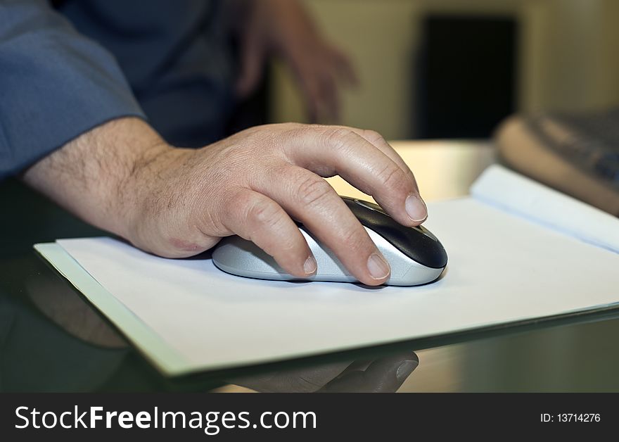 Hand on a mouse preparing a report in the meeting room. Hand on a mouse preparing a report in the meeting room