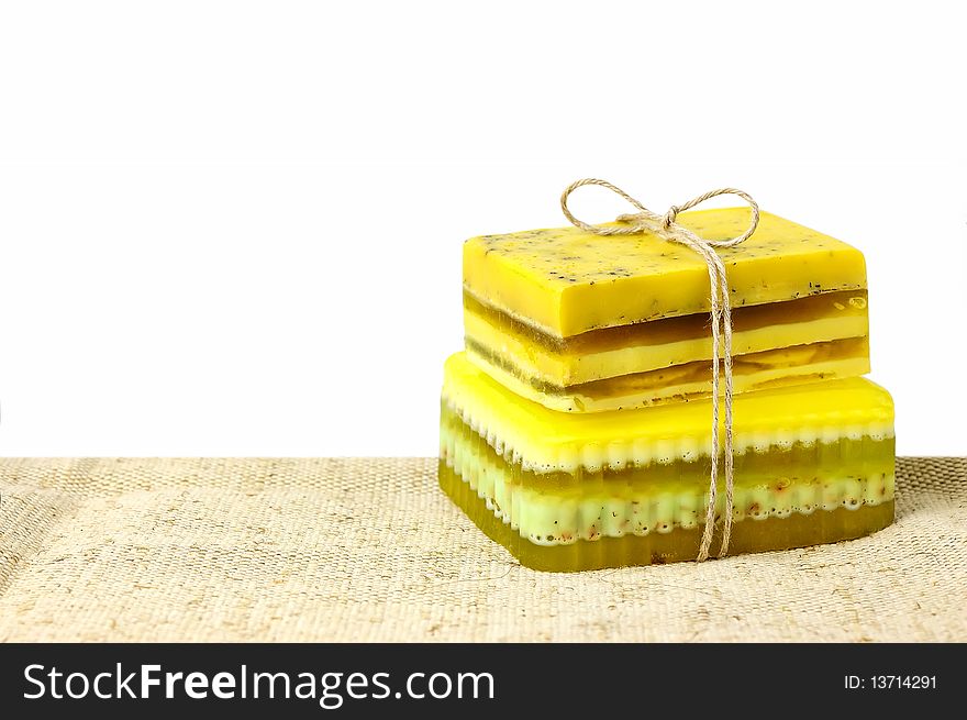 Pieces of handmade soap on sackcloth isolated on white