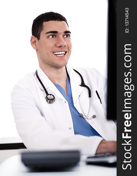 Smiling young doctor at his office over white background