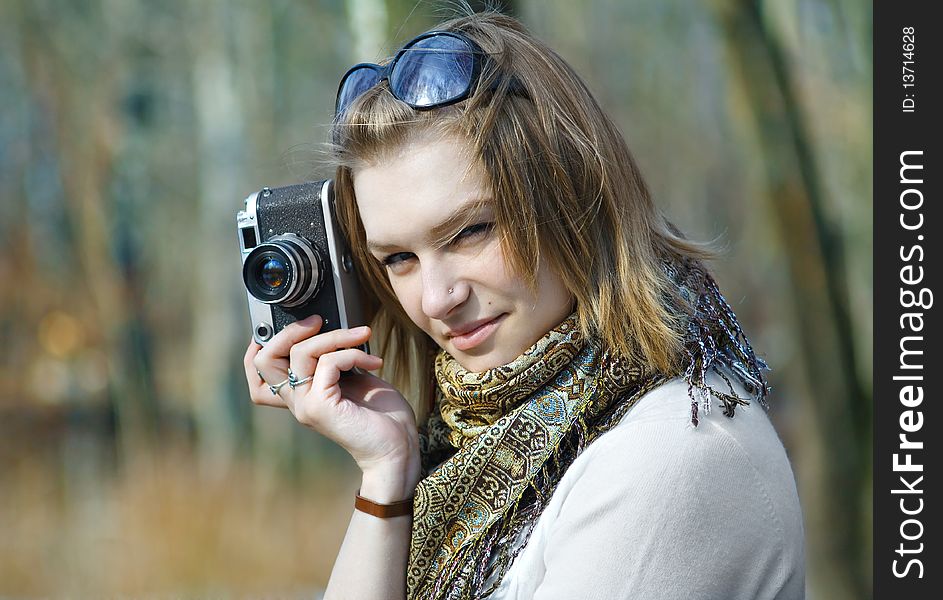 Beautiful young woman making photo using old camera. Beautiful young woman making photo using old camera