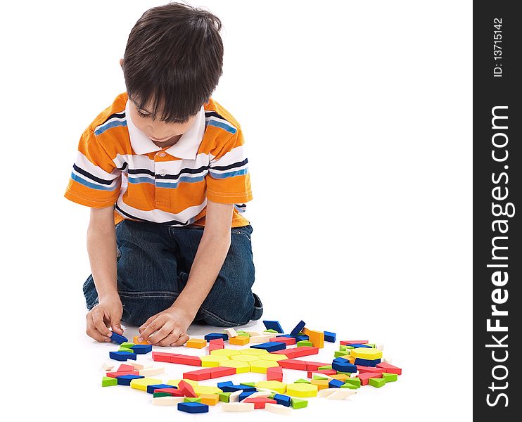 Adorable caucasian boy joining the blocks while playing on white background