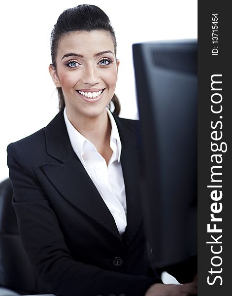 Closeup of young business woman in front of the computer over white background