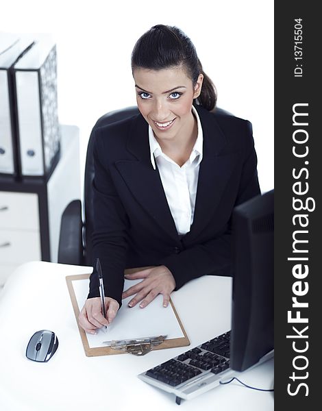 Business woman making notes and looking at the camera up at white background