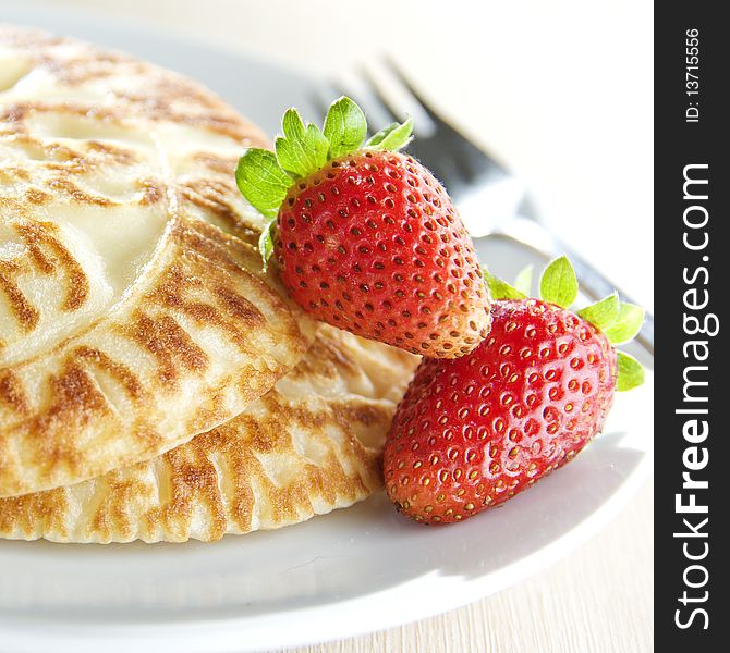 Close up shot of pancakes with strawberries on white plate. Close up shot of pancakes with strawberries on white plate