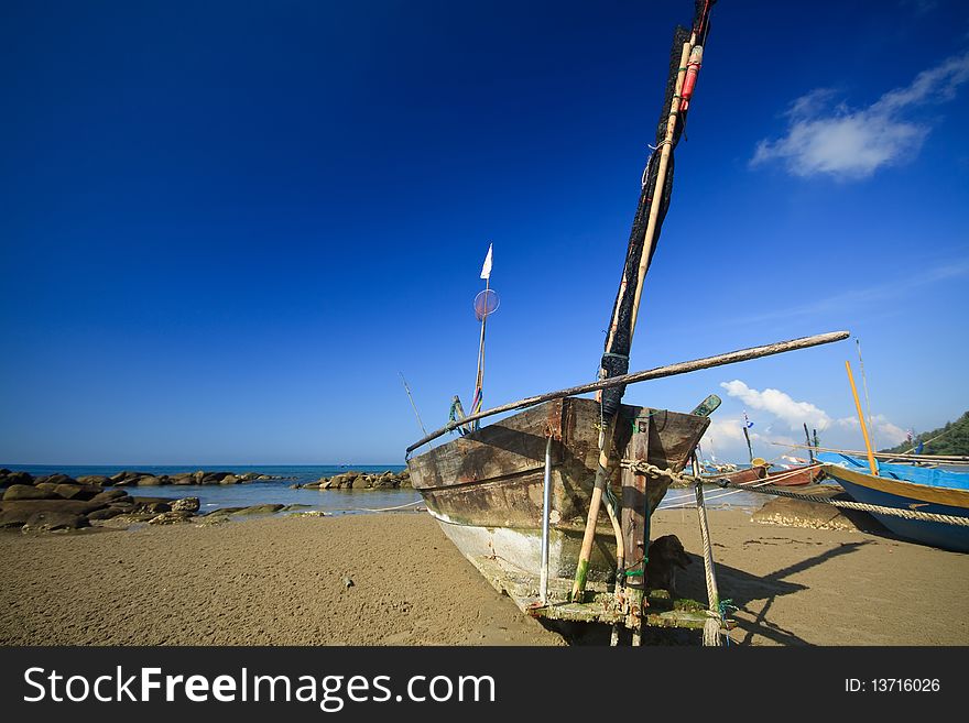 Old Row Boat on the beach with blue sky