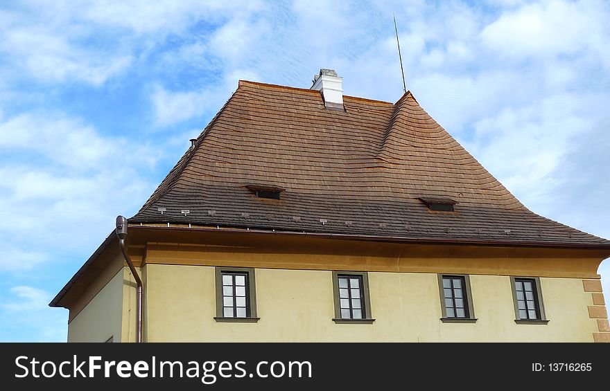 A house with golden roof in sunshine with the blue sky background.shoot in Cesky Krumlov of Czech . A house with golden roof in sunshine with the blue sky background.shoot in Cesky Krumlov of Czech .