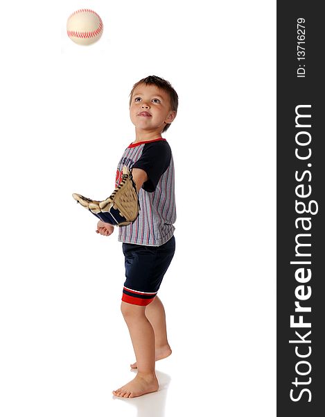 A preschooler practicing catching a baseball with a mitt. Isolated on white.