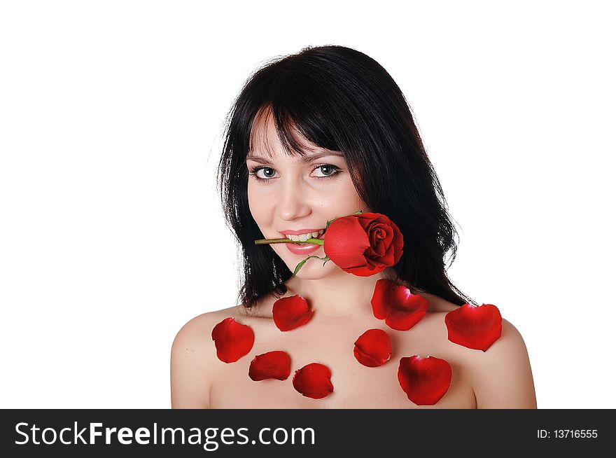 Young lovely brunette with a beautiful red rose petals strewn with roses