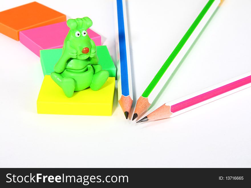 Colorful pencils, rubbers, and green monster
