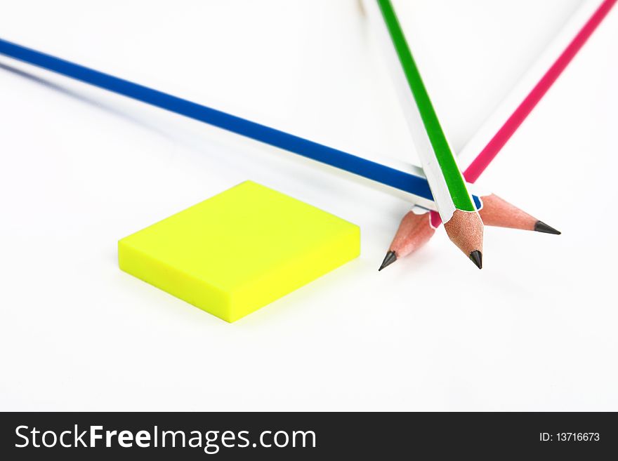 Colorful pencils crossed and yellow rubber