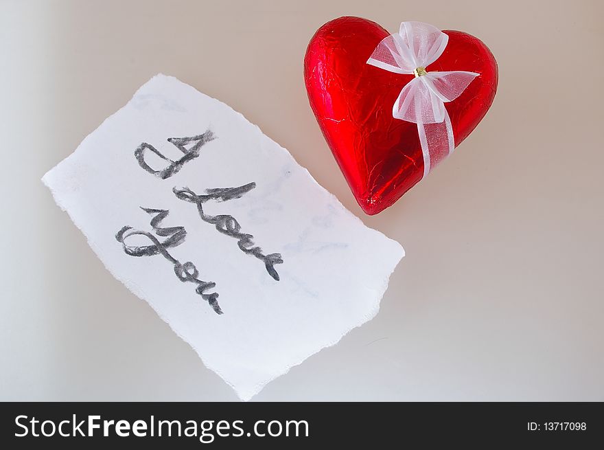 Valentine chocolate heart in red foil with white bow and note